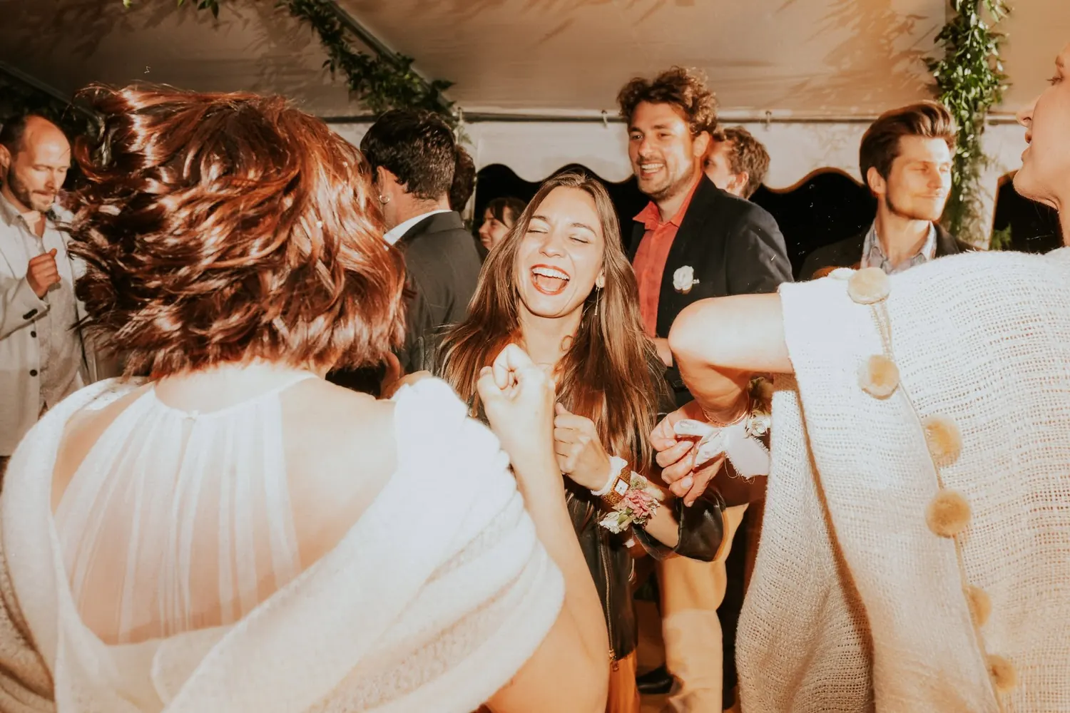 Laughing guests dancing at a wedding